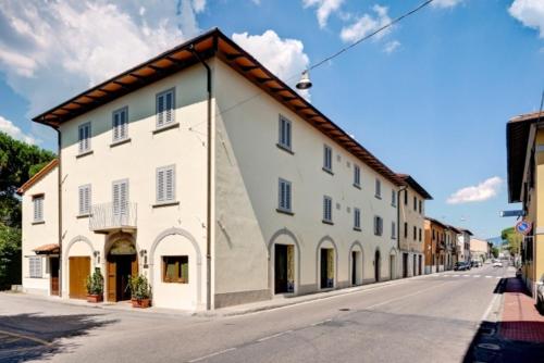 ein großes weißes Gebäude an der Straßenseite in der Unterkunft Hotel Il Cavallo in Barberino di Mugello