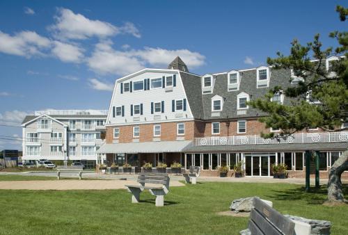 um grande edifício com bancos em frente em Newport Beach Hotel & Suites em Middletown