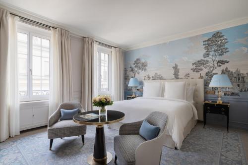 a bedroom with a bed and two chairs and a table at Four Seasons Hotel des Bergues Geneva in Geneva