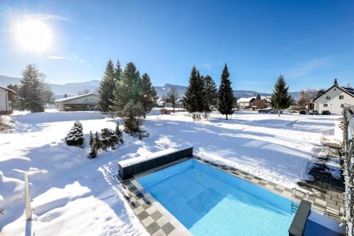 una piscina en un patio cubierto de nieve en Hotel-Restaurant Grimmingblick, en Bad Mitterndorf