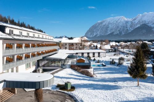 un resort en la nieve con una montaña en el fondo en Hotel-Restaurant Grimmingblick, en Bad Mitterndorf