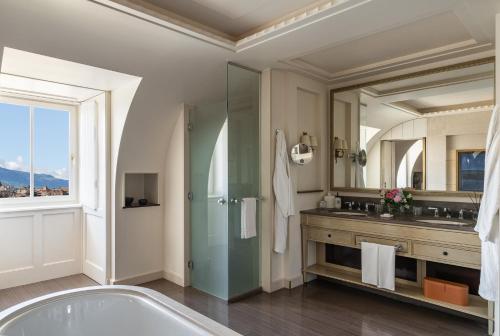 a bathroom with a tub and a large mirror at Four Seasons Hotel des Bergues Geneva in Geneva