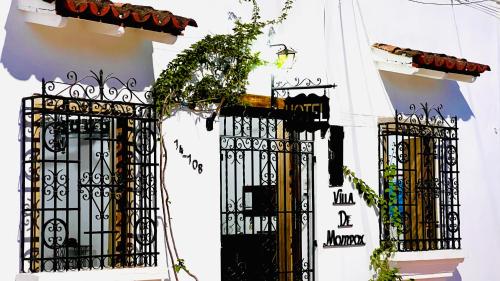 un bâtiment blanc avec des portes noires et une usine dans l'établissement Hotel Villa de Mompox, à Mompos