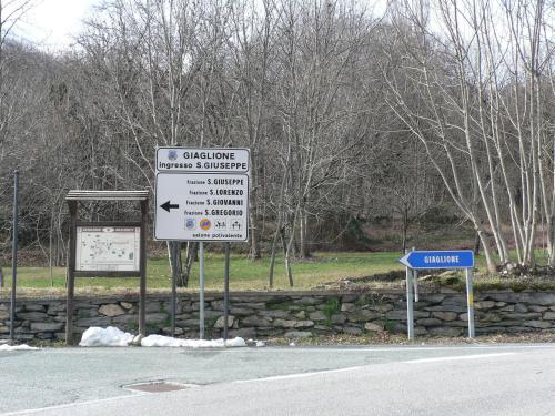 una señal en el lado de una carretera al lado de una calle en La Via del Sole, en Susa