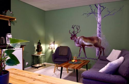 - un salon orné d'une peinture représentant un cerf sur le mur dans l'établissement Taigaschool Eco Hotel, à Virrankylä