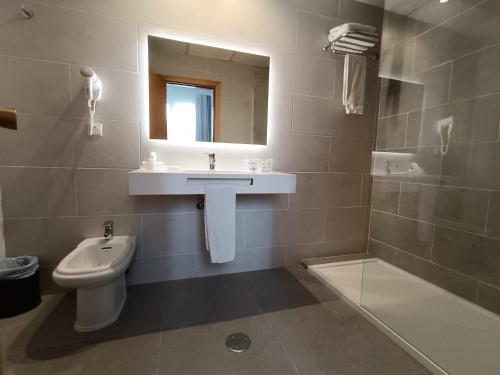 a bathroom with a sink and a toilet and a mirror at Mendez Nuñez Alicante in Alicante