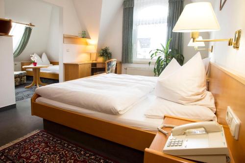 una camera con letto e scrivania con computer portatile di Hotel Heinz a Plauen