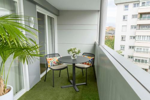 een klein balkon met een tafel en 2 stoelen bij NH Paseo de la Habana in Madrid