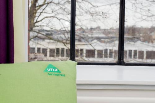 a green pillow sitting in front of a window at YHA Bristol in Bristol