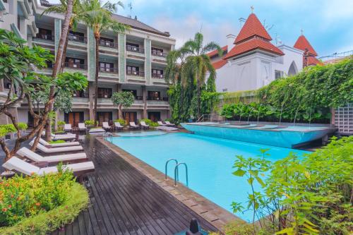 un hotel con piscina frente a un edificio en The Vira Bali Boutique Hotel & Suite, en Kuta