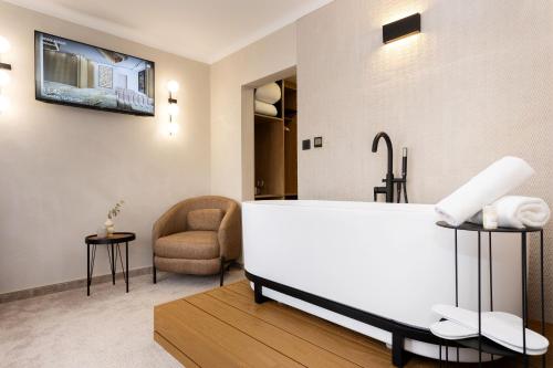 ein Badezimmer mit einer Badewanne und einem Stuhl in der Unterkunft AMAR Design Hotel by HMG in Sofia