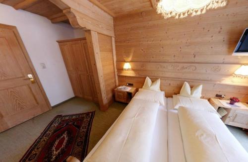 pokój z 3 łóżkami w drewnianym pokoju w obiekcie Hotel Sailer w mieście Sankt Anton am Arlberg