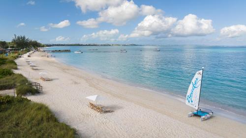 普罗维登西亚莱斯岛Beaches Turks and Caicos Resort Villages and Spa All Inclusive的海滩上摆放着椅子和帆船