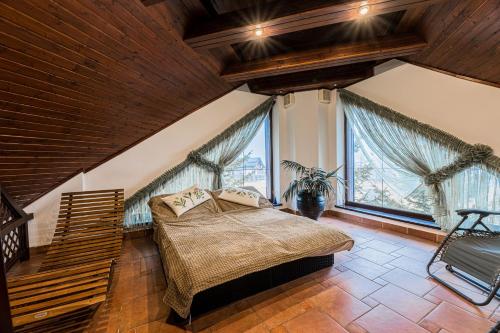 1 dormitorio con cama y ventana grande en Hotel Amalia, en Starý Smokovec