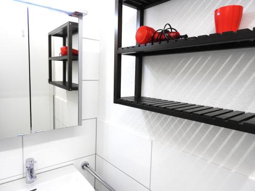 a bathroom with black shelves above a sink at INSIDE Five in Zürich