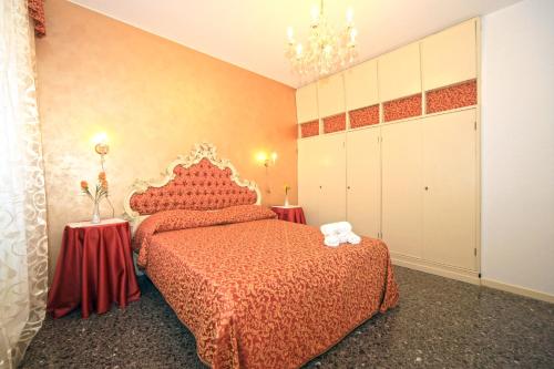 um quarto com uma cama com uma colcha vermelha em B&B Rialto Dream em Veneza