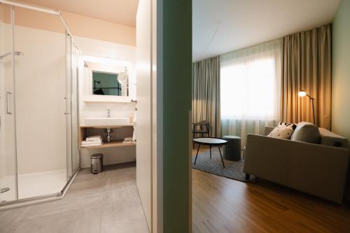 a bathroom with a shower and a living room at HausPension in Vienna