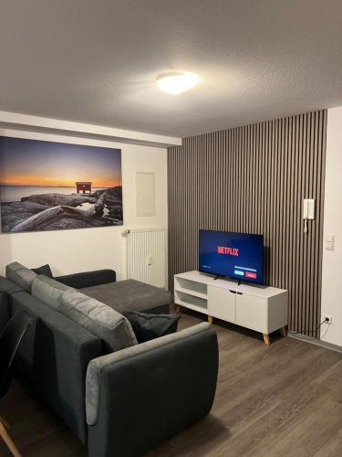 ein Wohnzimmer mit einem Sofa und einem Flachbild-TV in der Unterkunft City Unterkunft 4 in Heilbronn