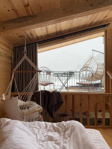 a bedroom with a bed and two chairs and a window at Hotel Borjomi Verde in Borjomi