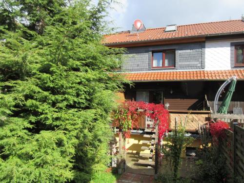 a house with a fence and a tree with red flowers at Ferienhaus Schulze in Schierke