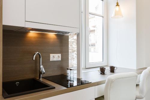 cocina con fregadero y ventana en Center Avenue Apartments, en Vilna