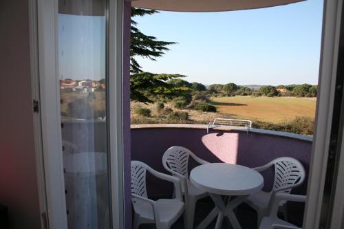 een balkon met een tafel en stoelen en een raam bij Vila in Lavanda in Fažana