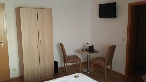 a room with a table and two chairs and a cabinet at Hotel Rheinkrone in Koblenz