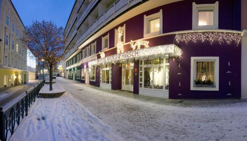 une rue enneigée devant un bâtiment dans l'établissement AKTIVHOTEL Weisser Hirsch, à Mariazell