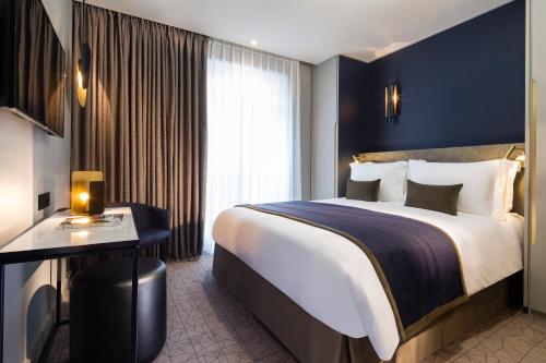 een hotelkamer met een groot bed en een raam bij Hotel Le 10 BIS in Parijs