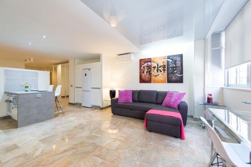 sala de estar con sofá y cocina en Suites Garden Loft Picasso, en Las Palmas de Gran Canaria