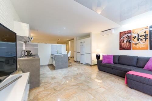 sala de estar con sofá y cocina en Suites Garden Loft Picasso, en Las Palmas de Gran Canaria