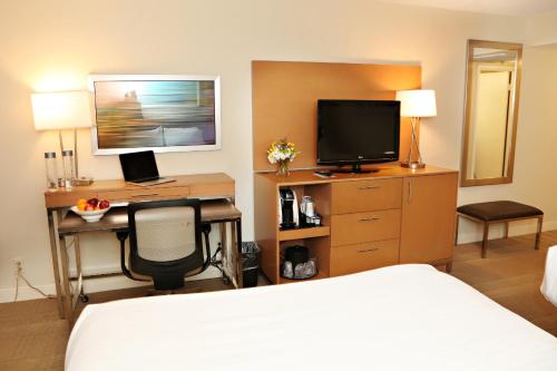 una camera d'albergo con letto e scrivania con TV di enVision Hotel & Conference Center Mansfield-Foxboro a Mansfield