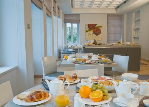 una mesa de desayuno con alimentos para el desayuno en Hotel Di Varese, en Varese