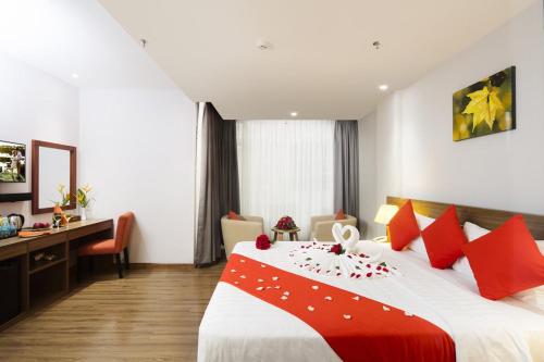 una habitación de hotel con una cama grande con almohadas rojas en Maple Leaf Hotel & Apartment, en Nha Trang