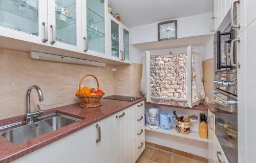 una cucina con armadi bianchi e lavandino di Holiday Home Piccolo Mondo a Dubrovnik