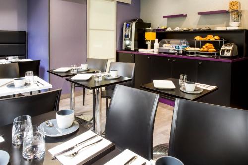 a restaurant with tables and chairs and a counter with food at Hotel des Savoies Lyon Perrache in Lyon