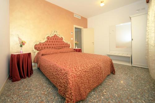 um quarto com uma cama com uma colcha vermelha em B&B Rialto Dream em Veneza