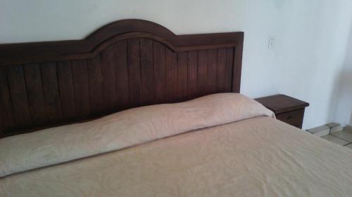 a bed with a wooden headboard in a bedroom at Hotel Real de Cuautla in Cuautla Morelos