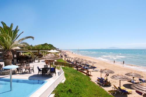 einen Strand mit Liegestühlen und Sonnenschirmen und dem Meer in der Unterkunft ROBINSON KYLLINI BEACH - All Inclusive in Kyllini