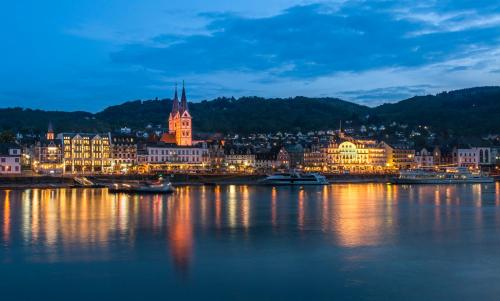 uma cidade iluminada à noite com barcos na água em Residence Bellevue em Boppard