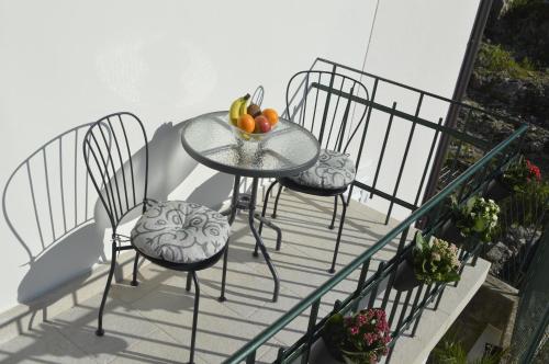 two chairs and a table with fruit on a balcony at Dubrovnik Rupe Apartment in Dubrovnik