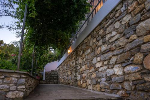 una pared de piedra junto a una pasarela en Villa Mitsa, en Kolios