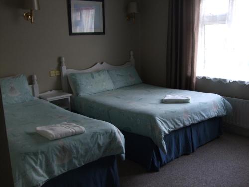 um quarto com 2 camas e uma janela em Harmony Inn - Glena House em Killarney