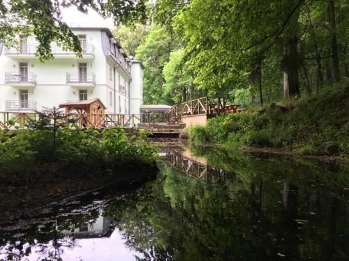 un puente sobre un río frente a un edificio en Parkhotel Forest, en Mariánské Lázně