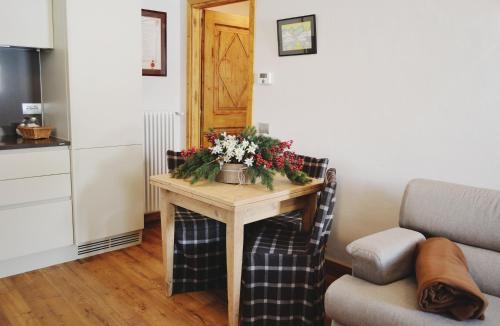 una sala de estar con una mesa con flores. en Maison Carrel Elegant 8, en Breuil-Cervinia