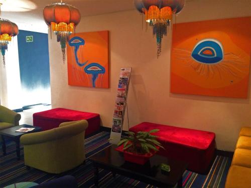 a waiting room with red stools and paintings on the wall at Premier Splendid Inn Bayshore in Richards Bay