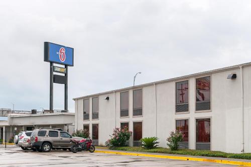 une voiture garée dans un parking devant un concessionnaire dans l'établissement Motel 6-New Orleans, LA - Near Downtown, à La Nouvelle-Orléans