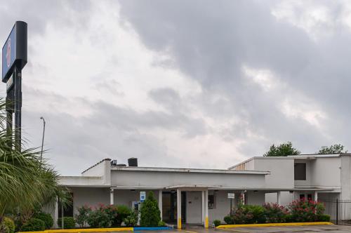 un bâtiment blanc avec un panneau dans un parking dans l'établissement Motel 6-New Orleans, LA - Near Downtown, à La Nouvelle-Orléans