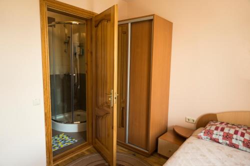 una camera da letto con doccia e mobile in legno di Viktoras Apartments a Palanga