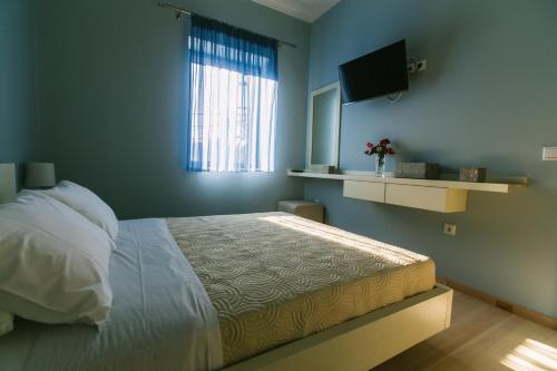 1 dormitorio con 1 cama y TV de pantalla plana en Maistros Kardamyli Apartments, en Kardhamili